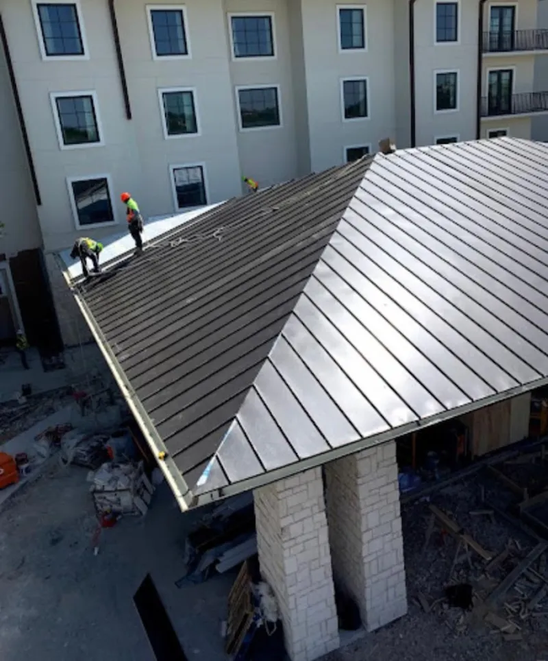 Crew installing standing seam metal roof panels on a commercial project in Middlesborough